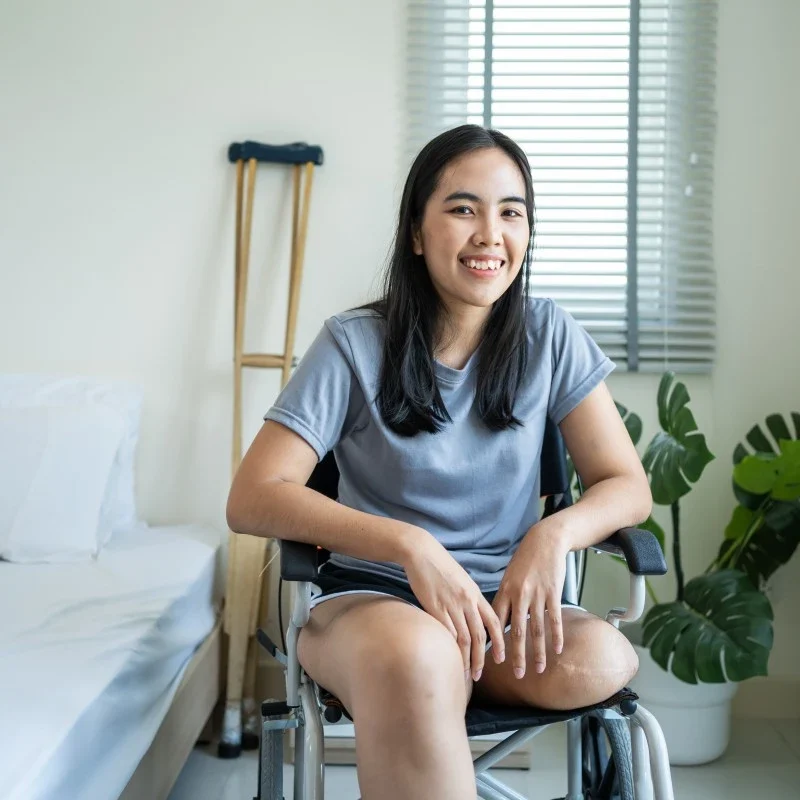 Disabled amputee woman sitting in wheelchair smiling at camera